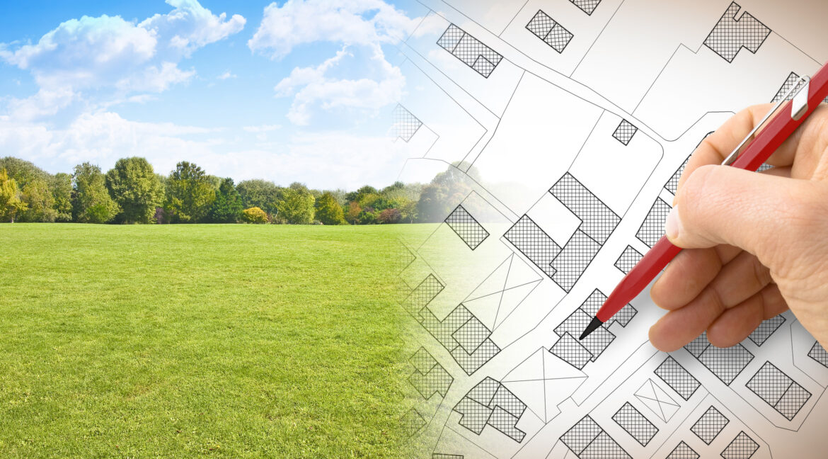 Planning a new city - concept image with hand drawing an imaginary cadastral map of territory with buildings, fields and roads against a green area